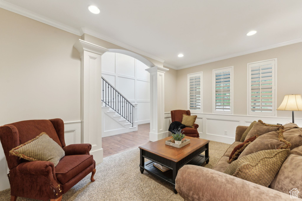 Living room with decorative columns, recessed lighting, stairs, and ornamental molding