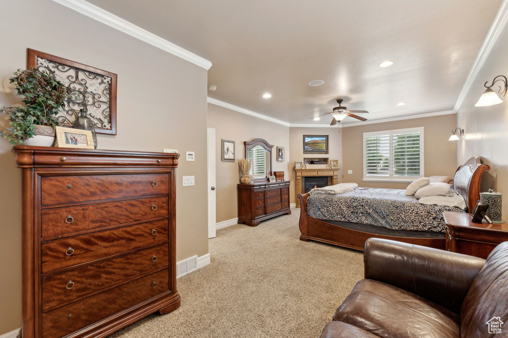 Bedroom featuring light carpet, a warm lit fireplace, ornamental molding, baseboards, and recessed lighting