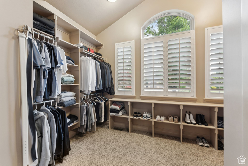 Walk in closet with vaulted ceiling and carpet