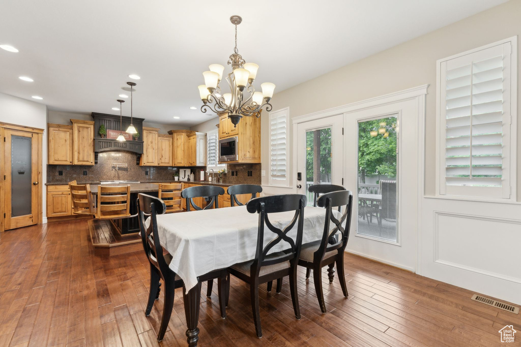 Dining room featuring a chandelier, dark wood-style flooring, and recessed lighting