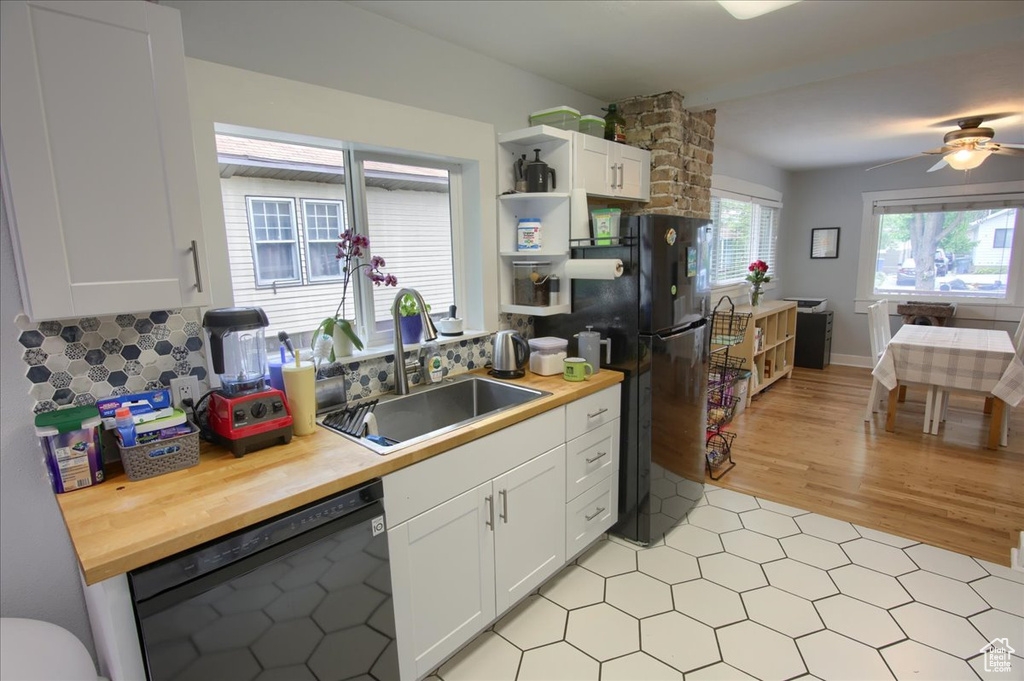 Kitchen featuring black appliances, wood counters, a sink, open shelves, and white cabinets