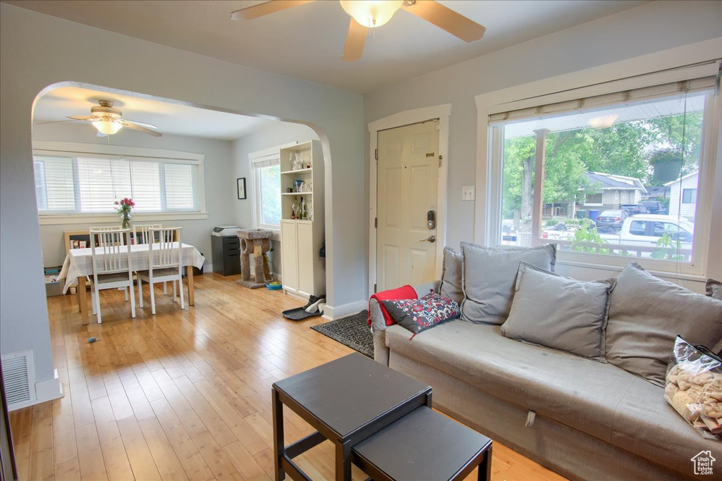 Living area with ceiling fan, arched walkways, and healthy amount of natural light