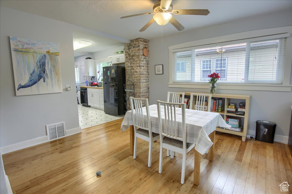 Dining room with a ceiling fan, light wood-type flooring, and baseboards