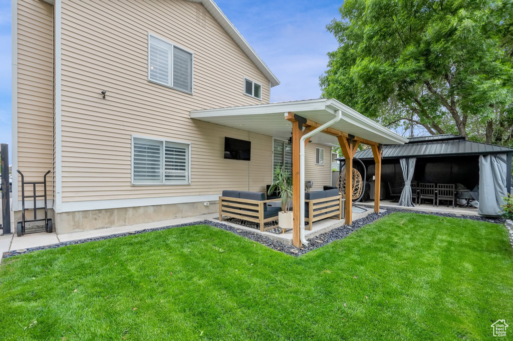 Back of house with an outdoor hangout area, a patio area, and a yard
