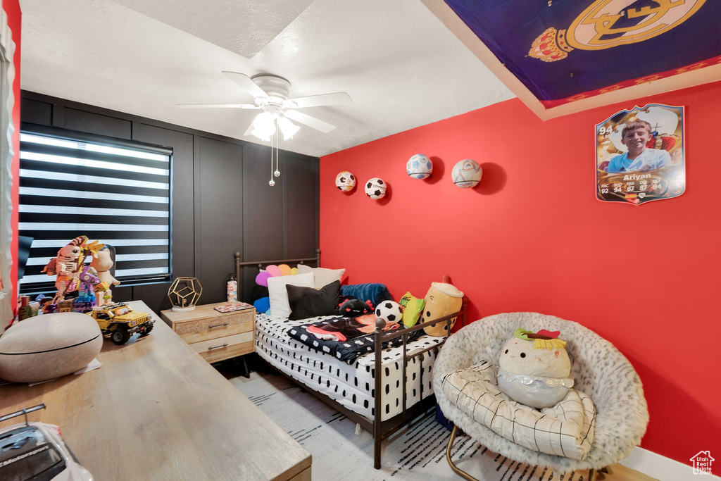 Bedroom featuring ceiling fan, wood finished floors, and baseboards