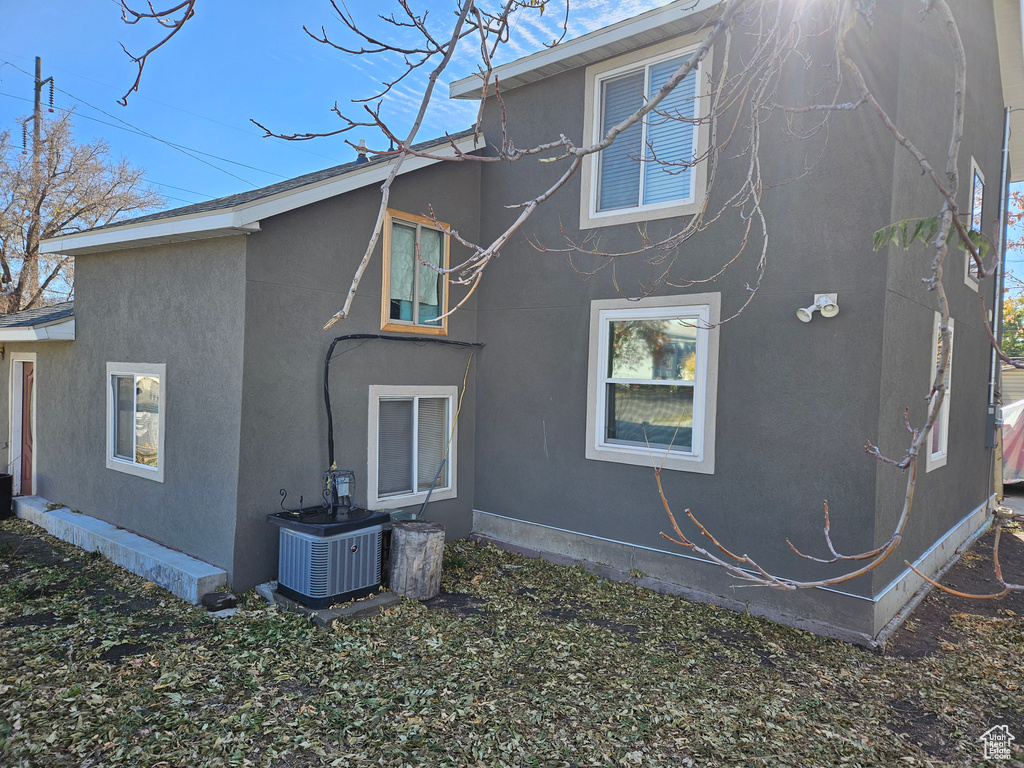 Back of property featuring central AC unit and stucco siding