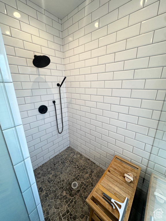 Full bath with stone flooring and a tile shower