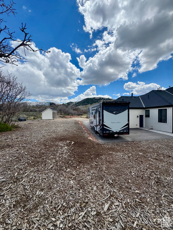 View of yard featuring a storage shed, a patio area, and an outdoor structure
