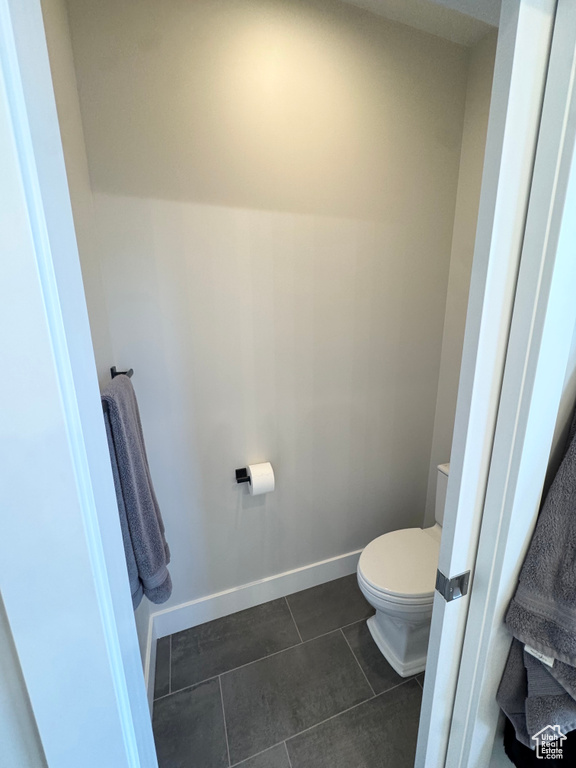 Bathroom with toilet, tile patterned flooring, and baseboards