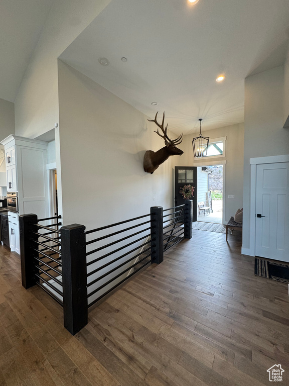 Hallway featuring an upstairs landing, dark wood-style floors, a chandelier, and recessed lighting