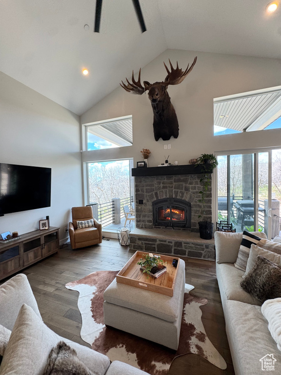 Living area with high vaulted ceiling, healthy amount of natural light, a fireplace, hardwood / wood-style floors, and recessed lighting