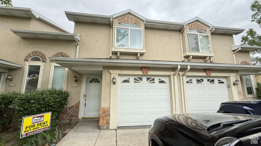 View of property with stucco siding and an attached garage