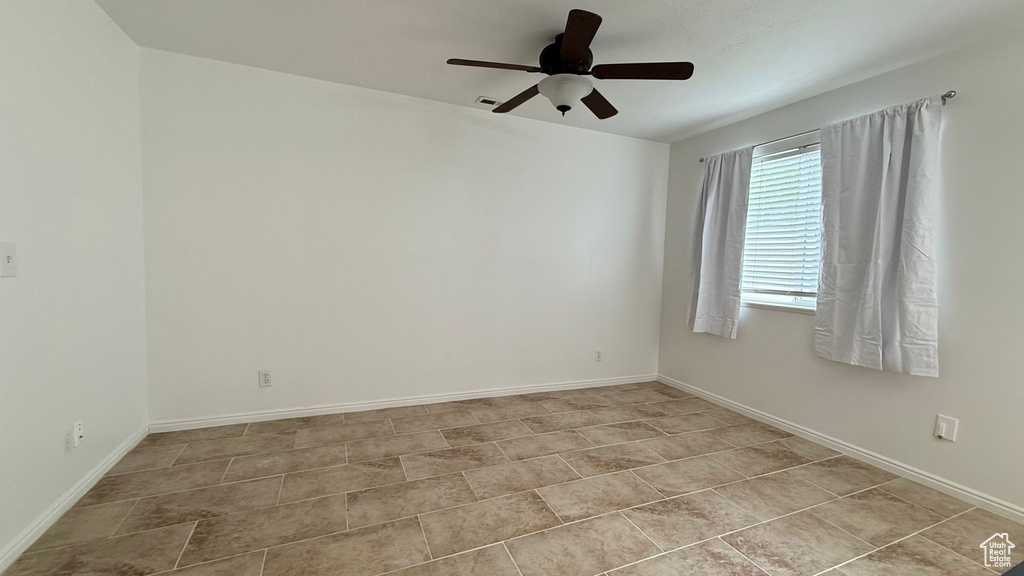 Spare room featuring ceiling fan and baseboards