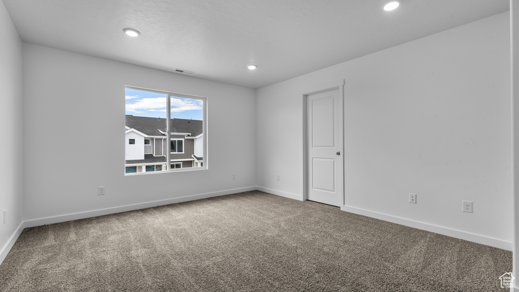 Carpeted empty room with baseboards and recessed lighting