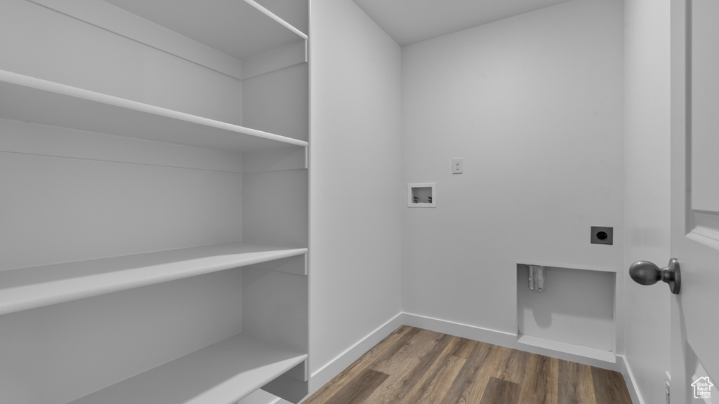 Laundry room with hookup for an electric dryer, hookup for a washing machine, dark wood finished floors, and baseboards