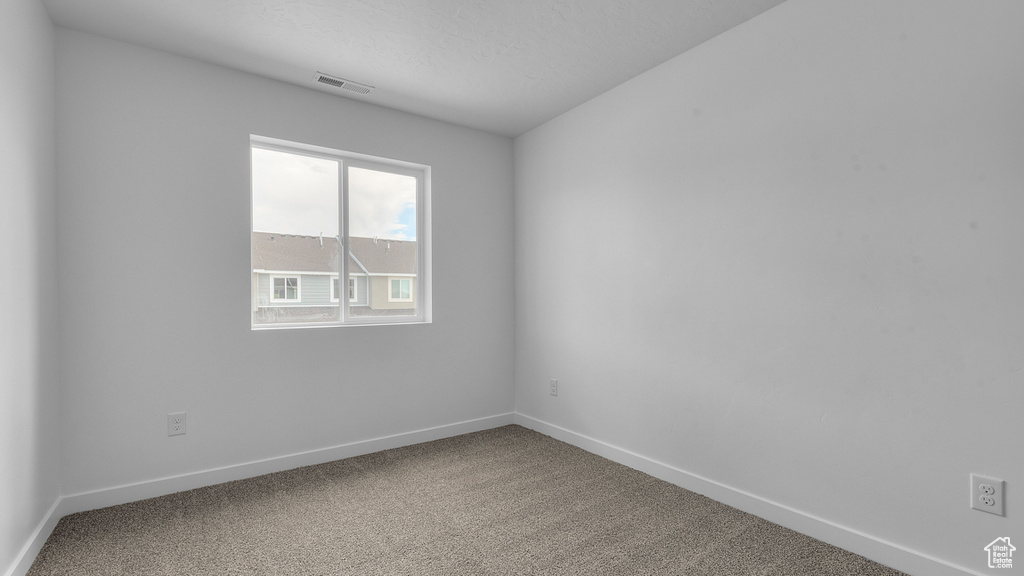 Carpeted empty room featuring baseboards