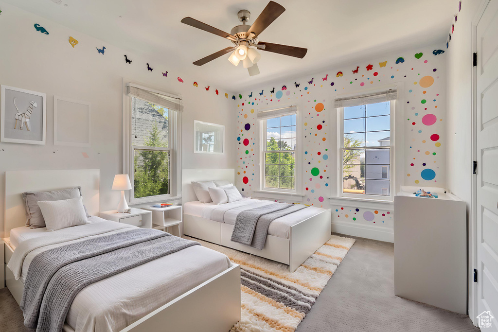 Bedroom with light colored carpet and a ceiling fan