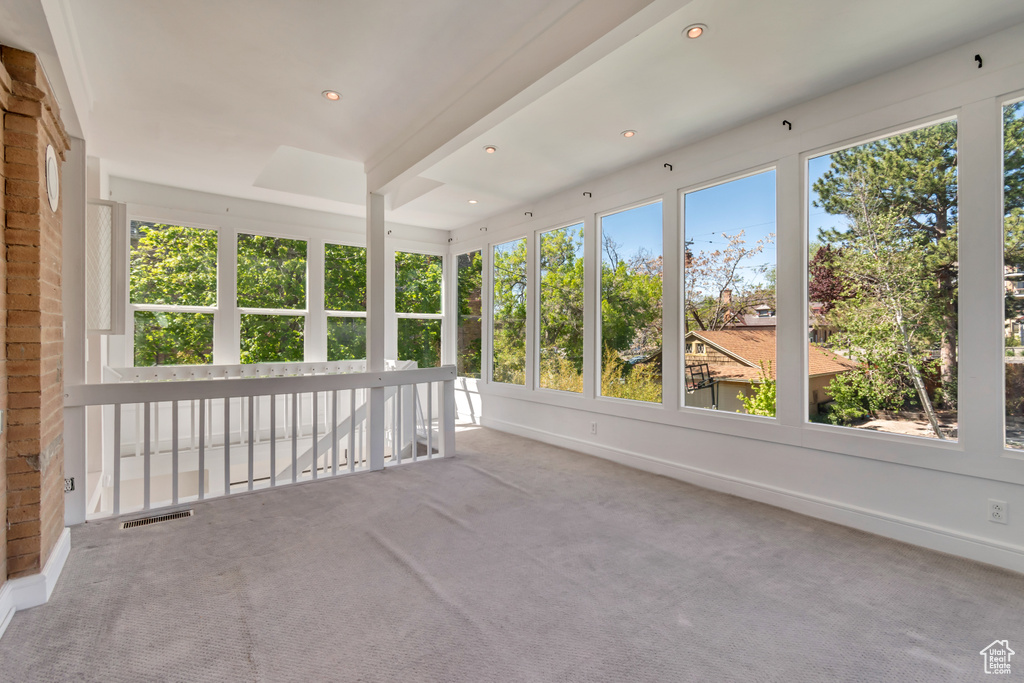 Unfurnished sunroom with healthy amount of natural light, carpet flooring, and recessed lighting