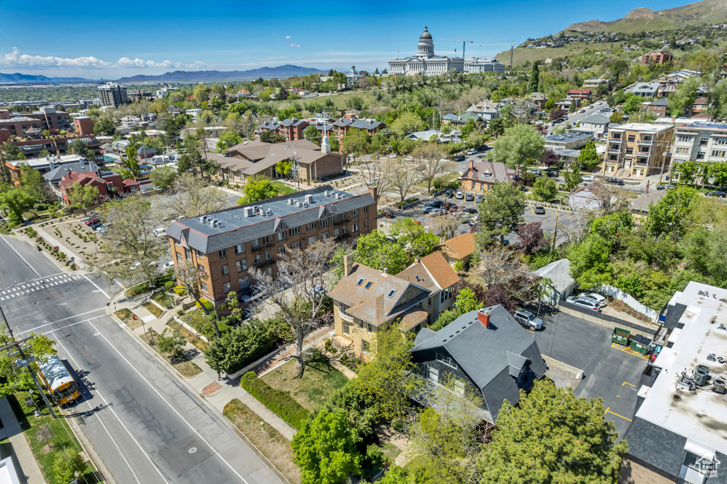 Aerial view of property and surrounding area featuring a mountainous background and nearby suburban area