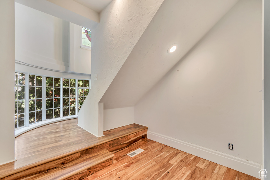 Additional living space with wood finished floors, baseboards, and recessed lighting