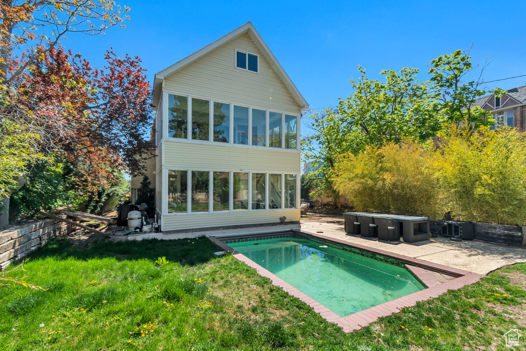 Back of house with a sunroom, a patio area, and a yard