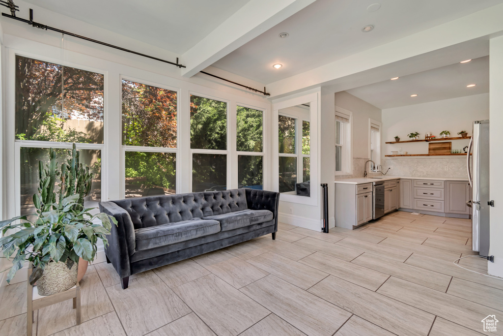 Sunroom with beamed ceiling, a sink, and recessed lighting