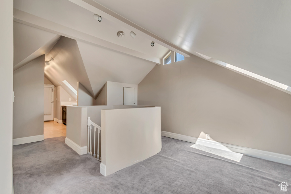 Additional living space with carpet, vaulted ceiling, and baseboards