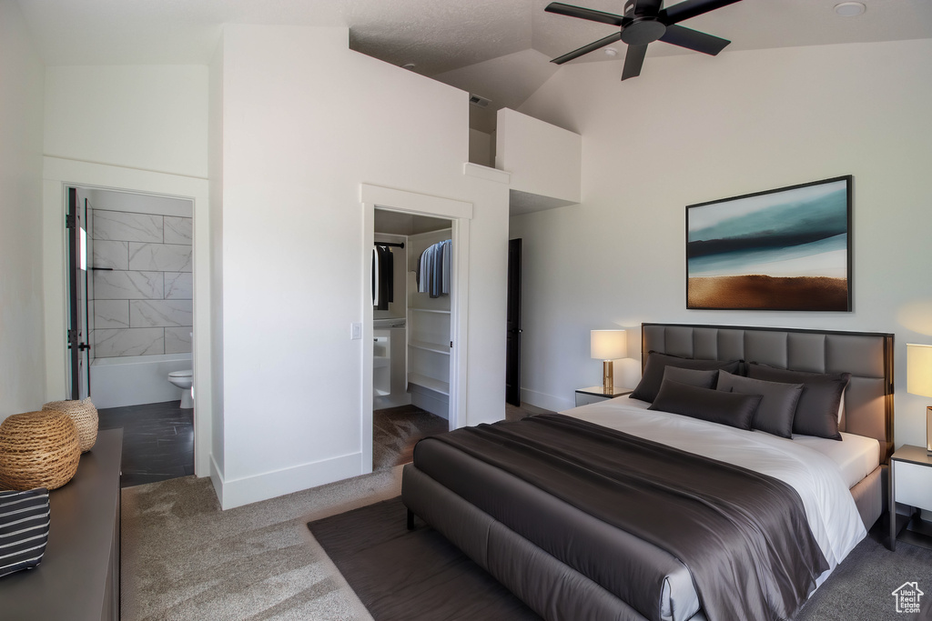 Bedroom featuring carpet flooring, baseboards, high vaulted ceiling, and ensuite bath