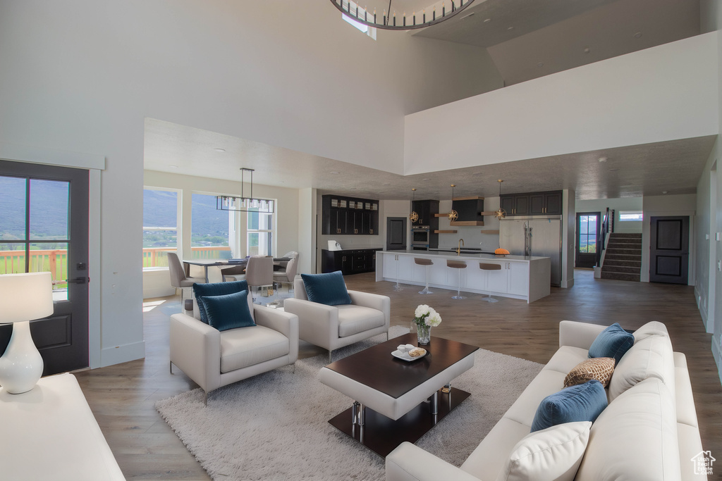 Living area with a towering ceiling, light wood-style flooring, and baseboards