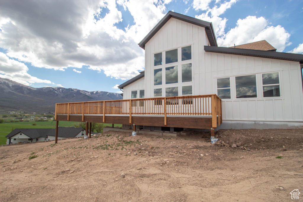 Back of house with a deck with mountain view and board and batten siding