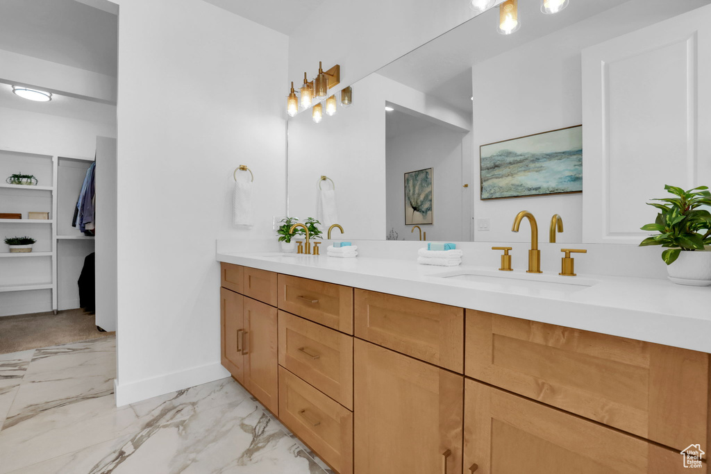 Full bathroom featuring baseboards, marble look tile flooring, and double vanity