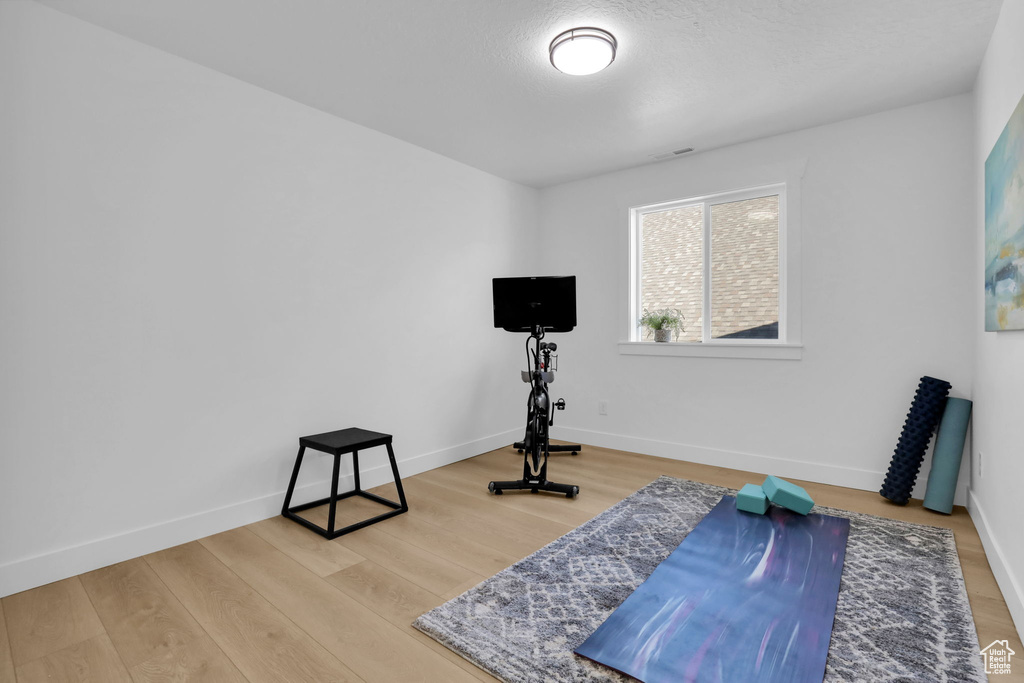 Exercise room with wood finished floors and baseboards