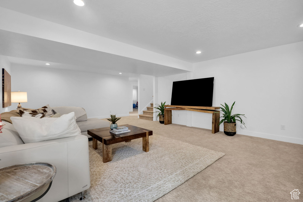 Carpeted living area featuring recessed lighting, stairway, and baseboards
