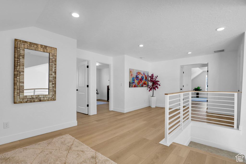Empty room featuring baseboards, light wood-style flooring, and recessed lighting