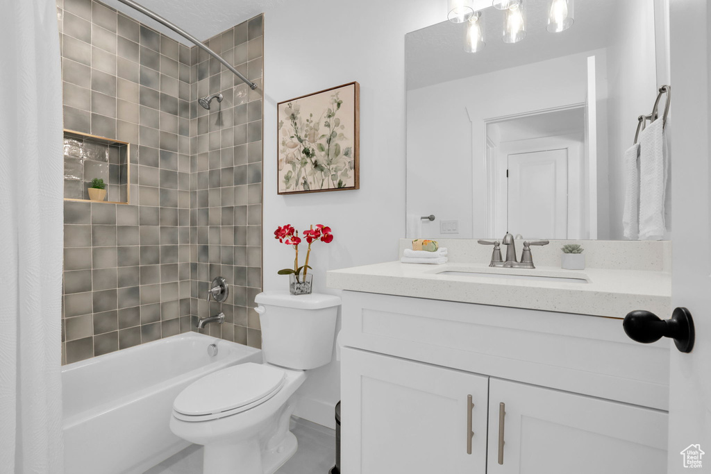 Full bathroom featuring shower / bath combo with shower curtain, vanity, and toilet