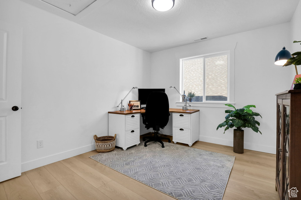 Office with light wood-style flooring and baseboards