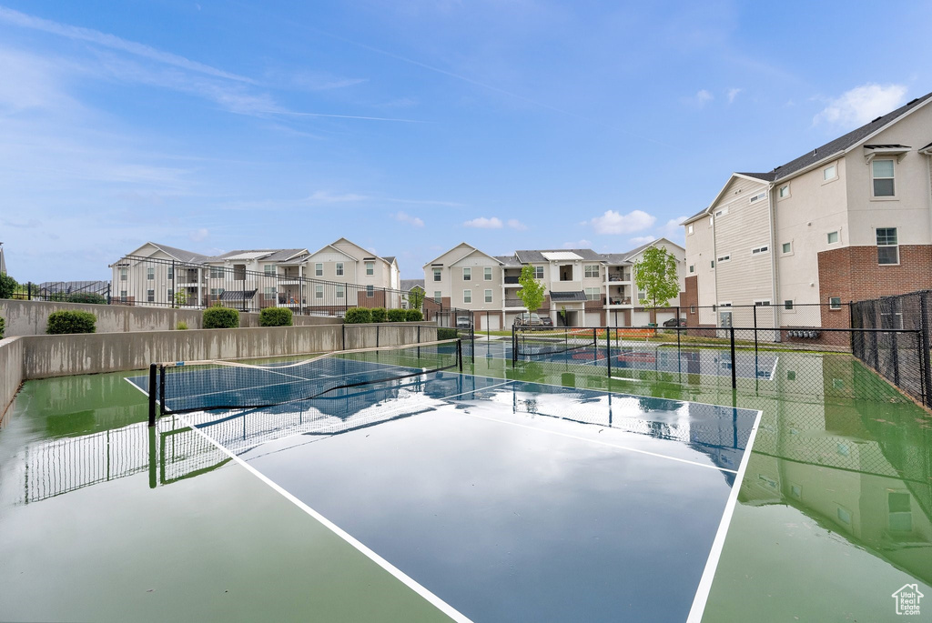 View of tennis court featuring a residential view and fence