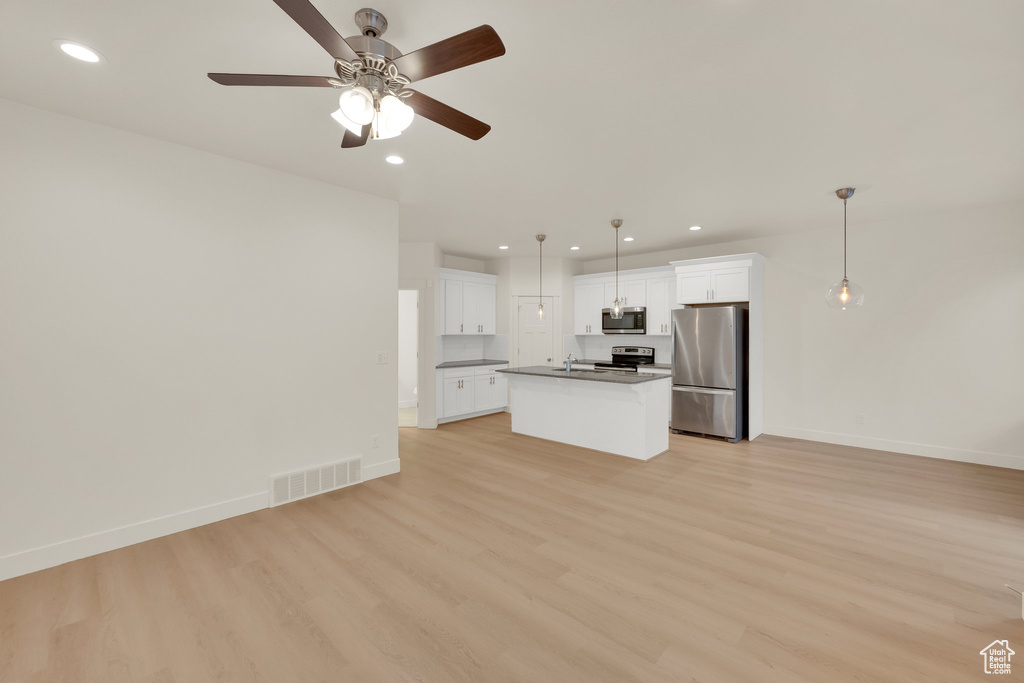 Unfurnished living room featuring light wood-type flooring, a ceiling fan, baseboards, recessed lighting, and a sink