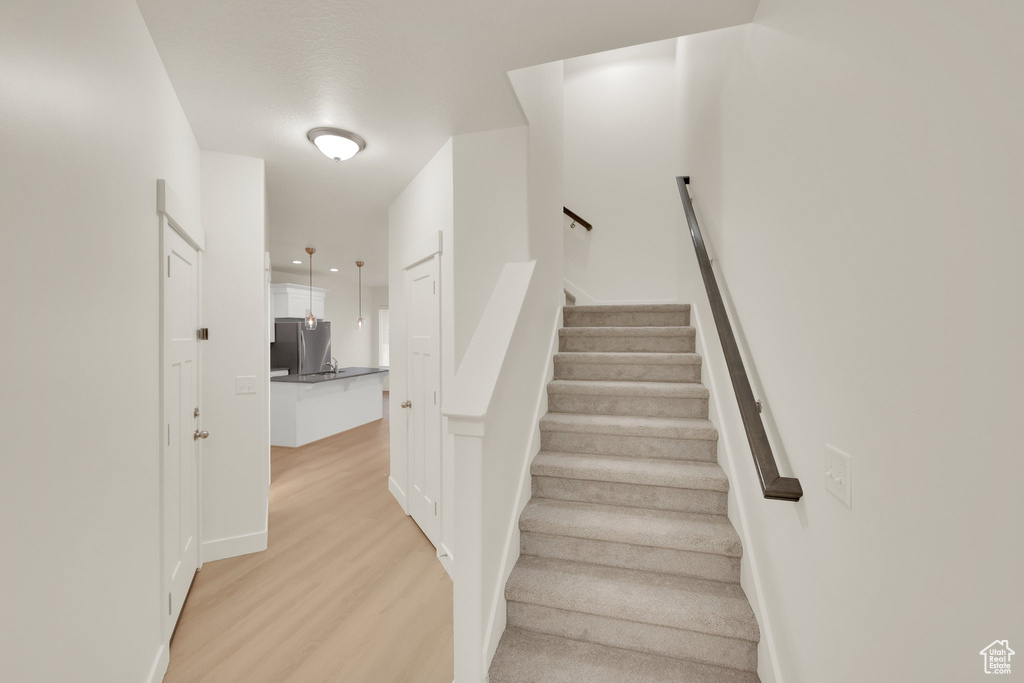 Stairs featuring wood finished floors and baseboards