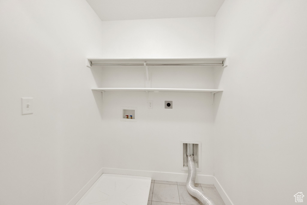 Laundry area featuring hookup for an electric dryer, light tile patterned flooring, baseboards, hookup for a washing machine, and gas dryer hookup