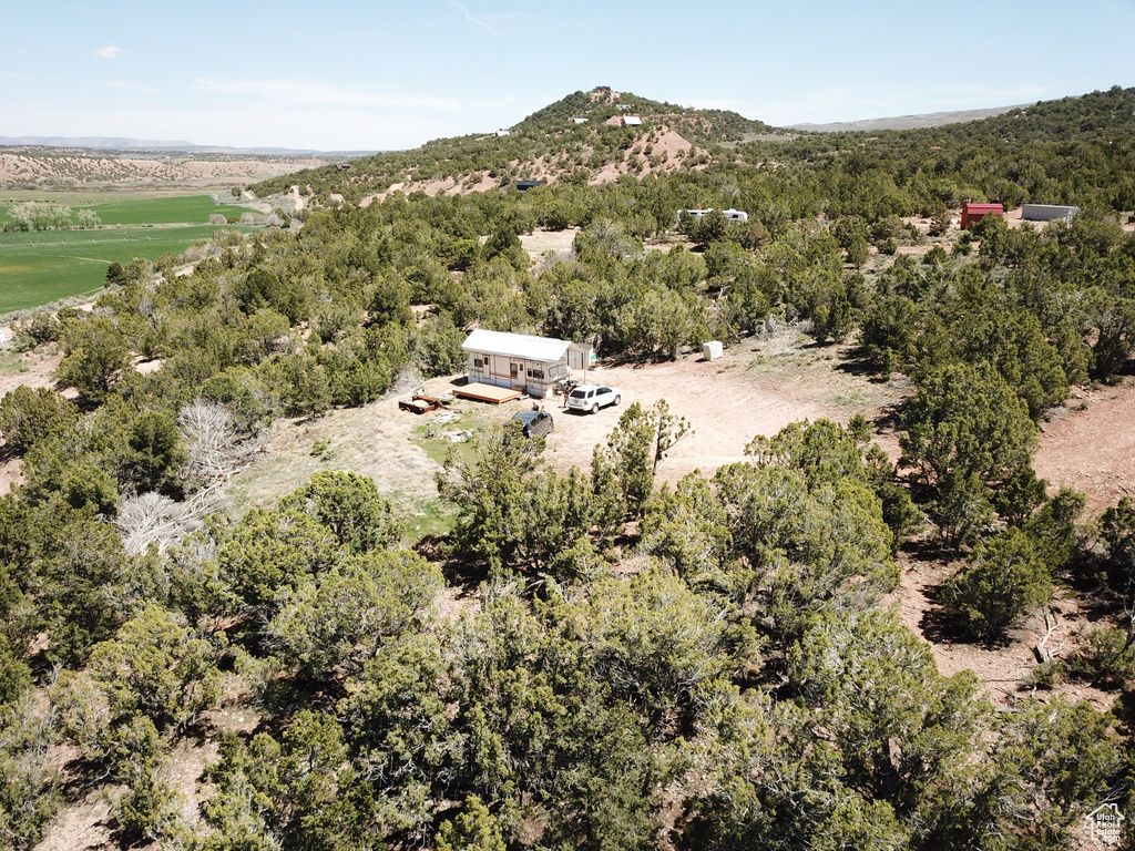 Aerial view of property and surrounding area with a heavily wooded area