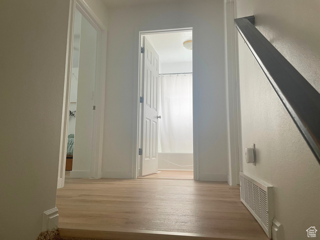 Corridor featuring wood finished floors and baseboards