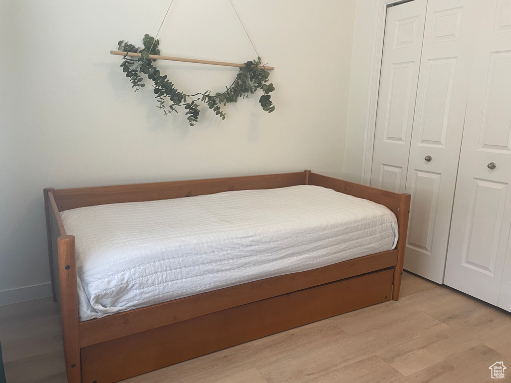 Bedroom with light wood-style floors and a closet