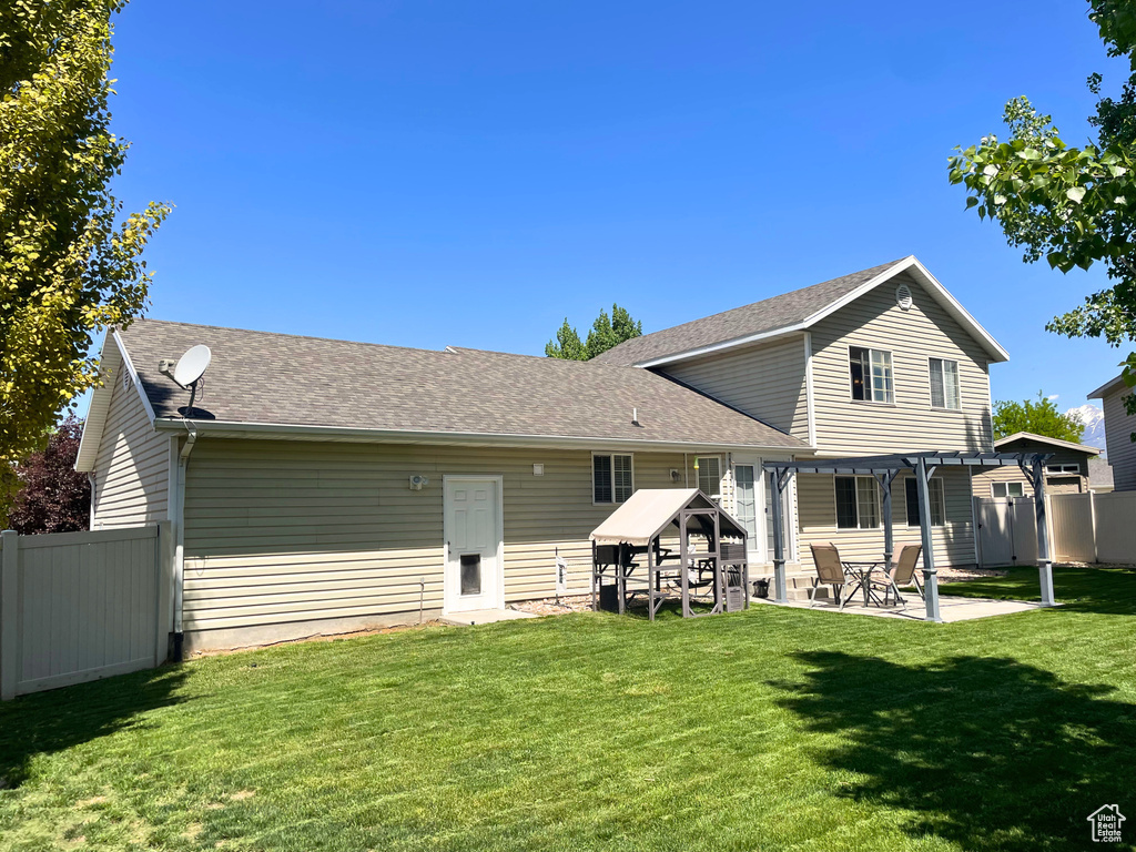 Rear view of property with a patio and a shingled roof