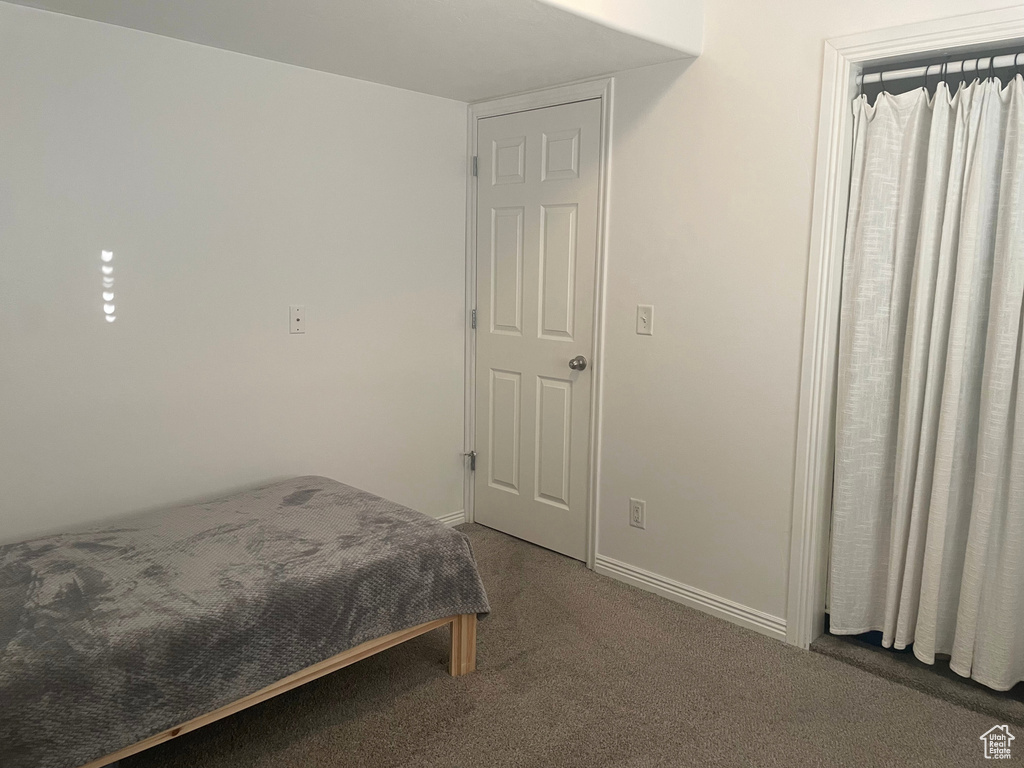 Bedroom featuring carpet flooring and baseboards