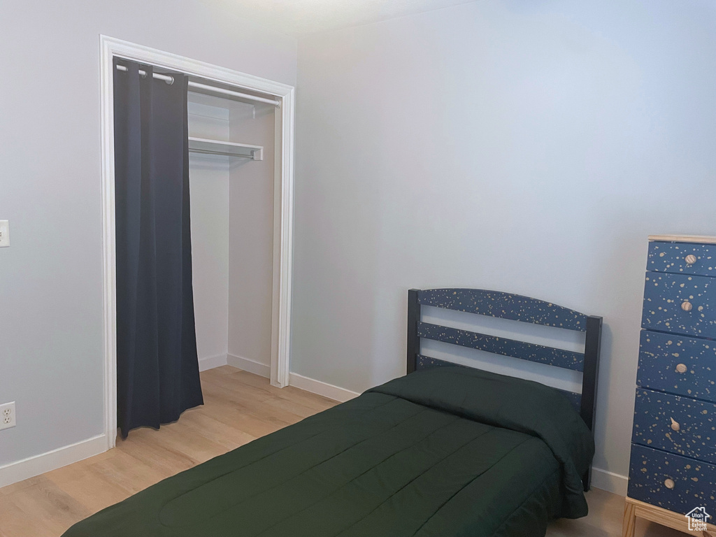 Bedroom with wood finished floors and baseboards