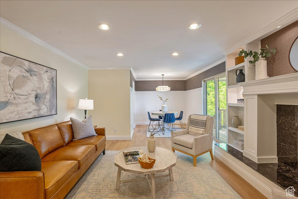 Living room featuring wood finished floors, recessed lighting, baseboards, and crown molding