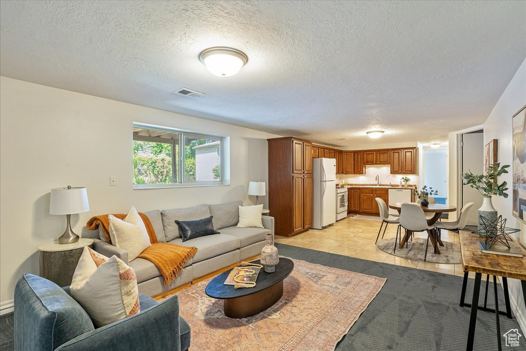 Living area featuring a textured ceiling and light tile patterned floors