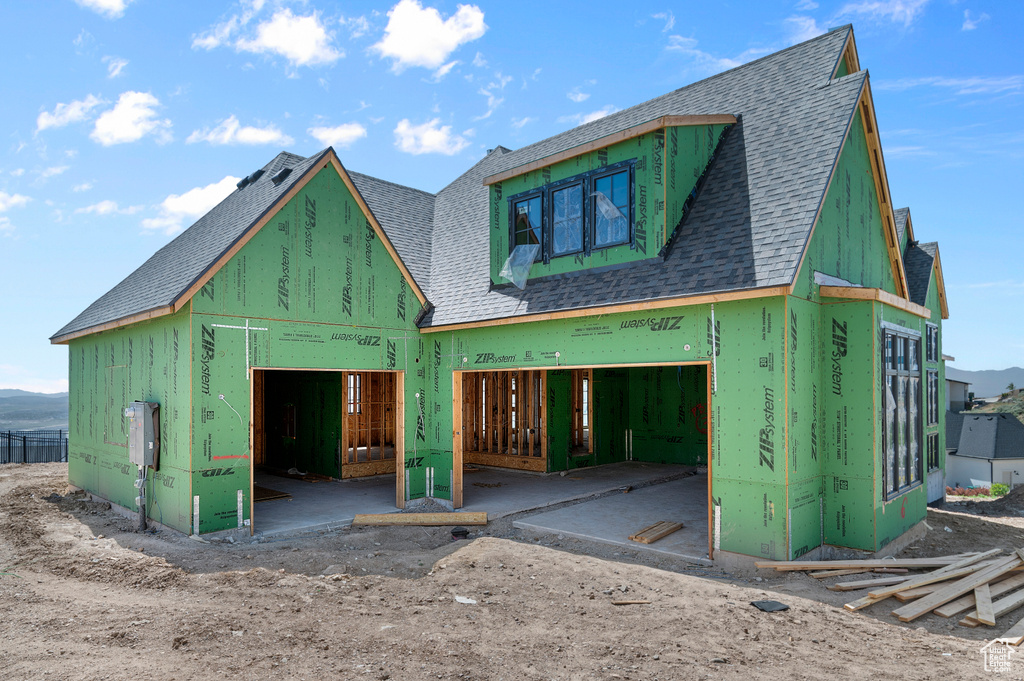 View of front of property with roof with shingles and a garage