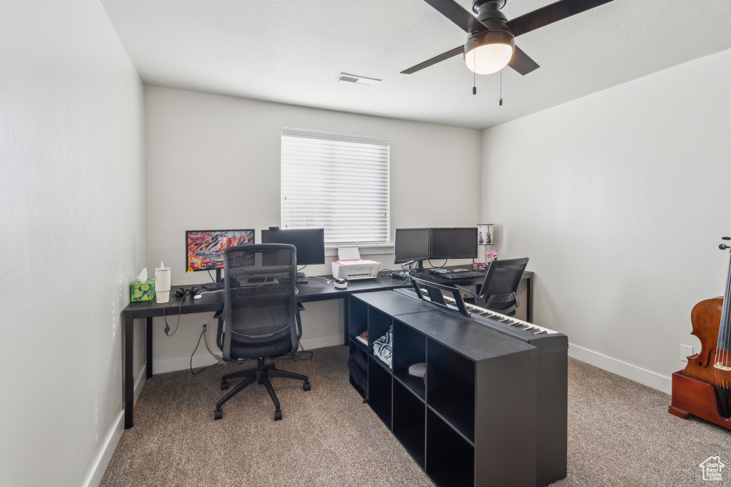 Carpeted office featuring ceiling fan and baseboards